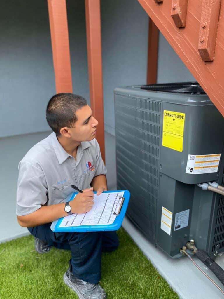 AC technician performing maintenance on a condensing unit in Boynton Beach.