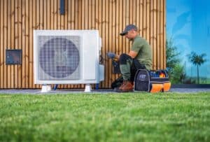 ac repair company Boyntong BEach, Technician Performing Maintenance on Air Conditioning Unit in Residential Garden During Daytime